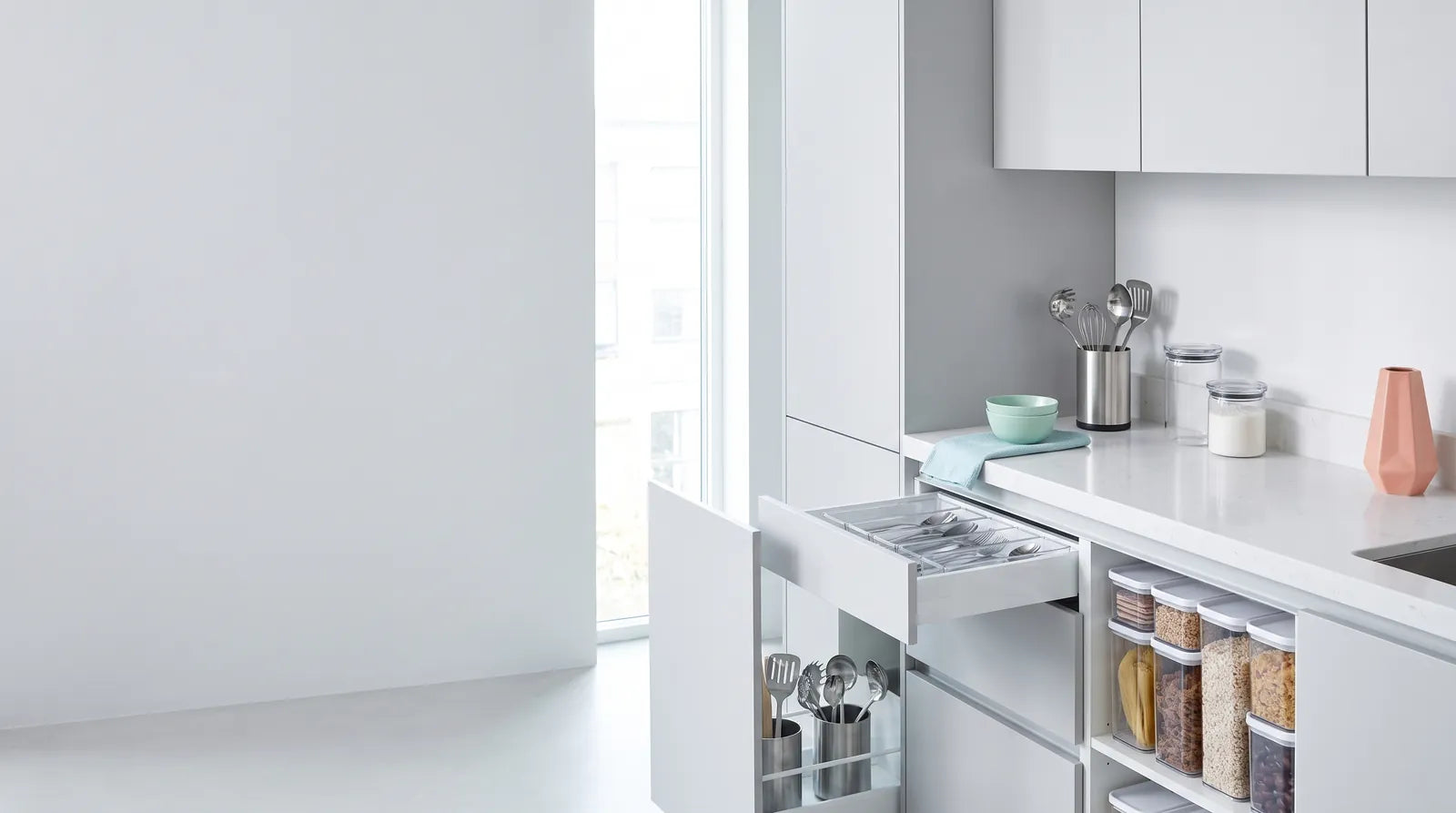 Cocina moderna en blanco y gris claro con organizadores transparentes y detalles en tonos pastel